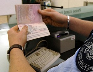 Immigration desk, man holding passport