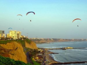 paragliding over the ocean by the top of seafront cliff of miraflores