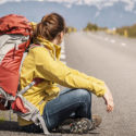 backpacker waiting on the side of the road